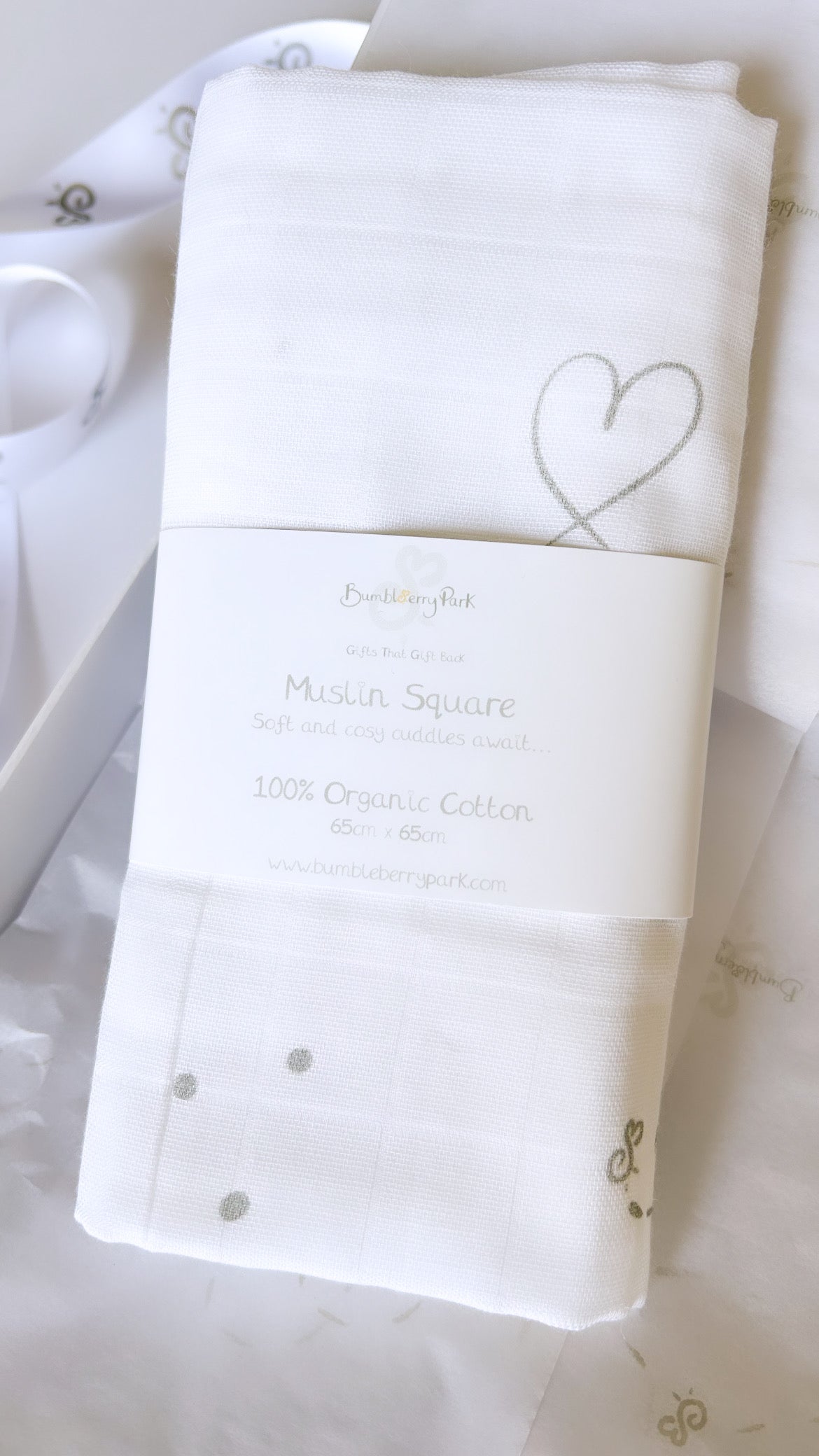 organic cotton new baby muslin cloth with neutral grey prints of hearts, stars and bees with a card belly band wrap
