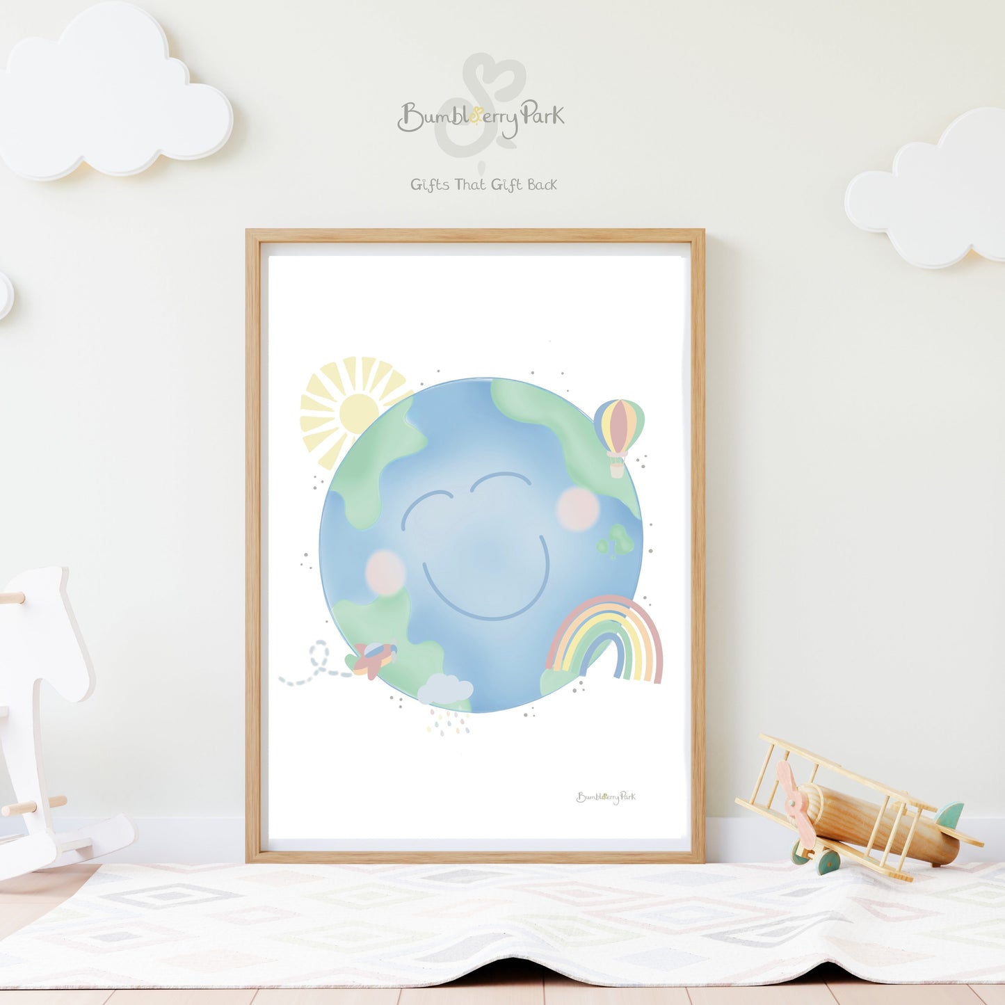 our earth pastel nursery print with rainbows aeroplane and sunshine illustrations framed on a nursery wall