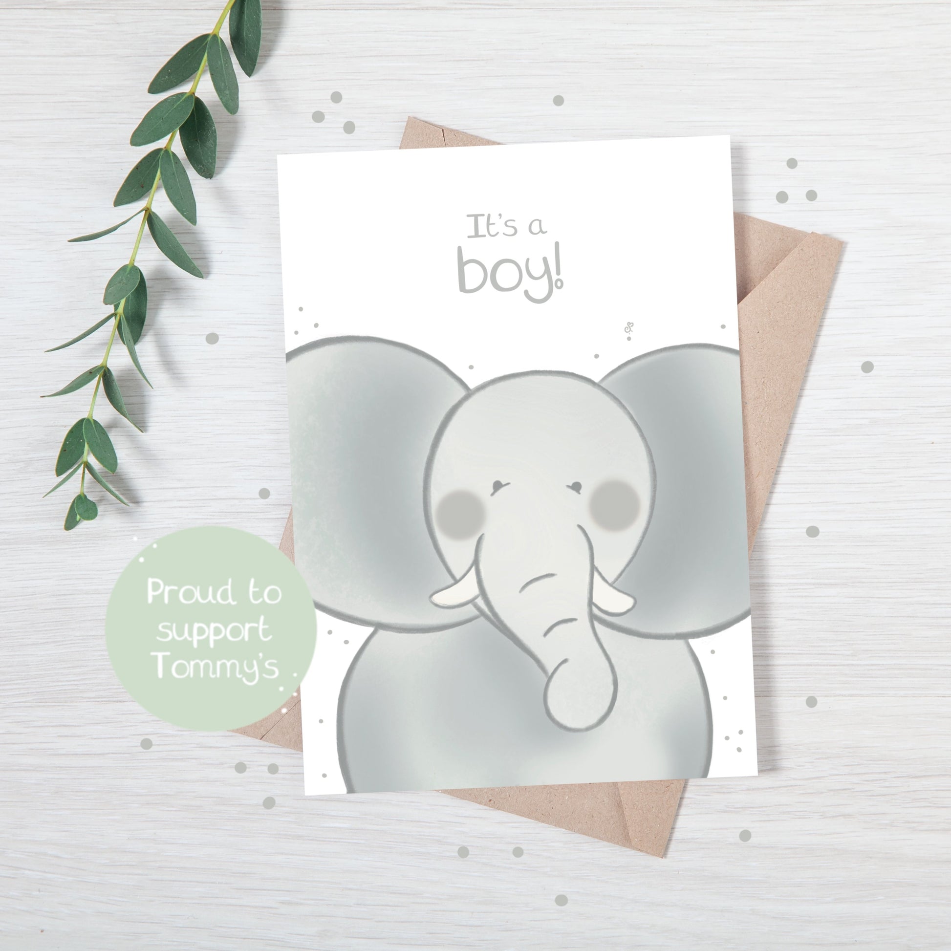 Handmade luxury new baby christening greetings card with a safari theme baby elephant popping up from the bottom with the title &quote "it's a boy" on a white background, with a kraft envelope