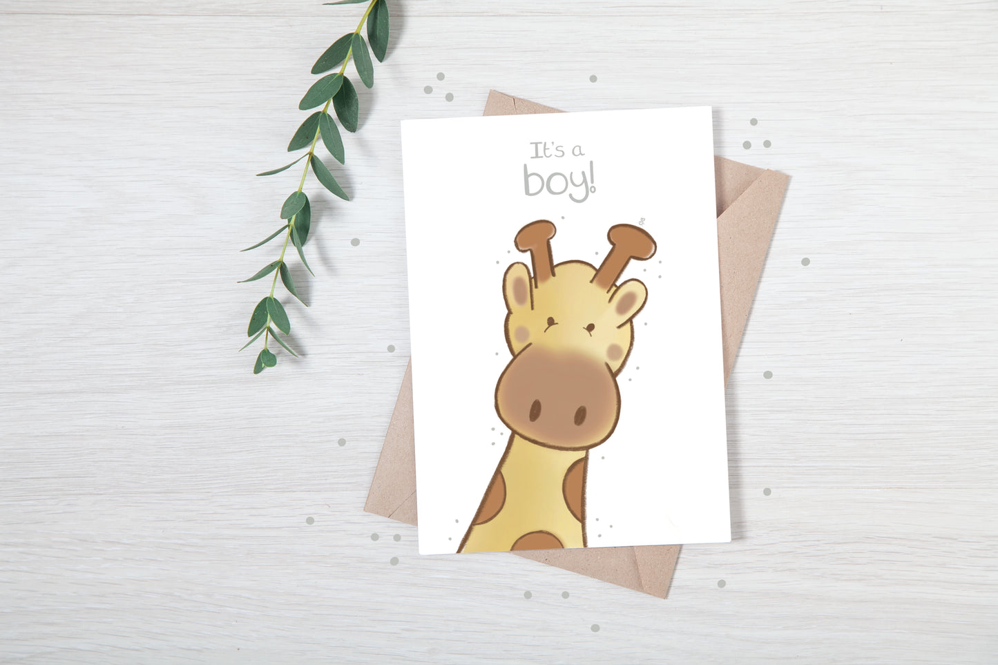 Handmade luxury new baby christening greetings card with a safari theme baby giraffe popping up from the bottom with the title &quote "it's a boy" on a white background, with a kraft envelope