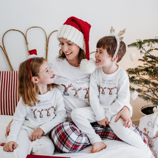 family of mum son and daughter wearing matching christmas pyjamas with cute festive personalised reindeer designs
