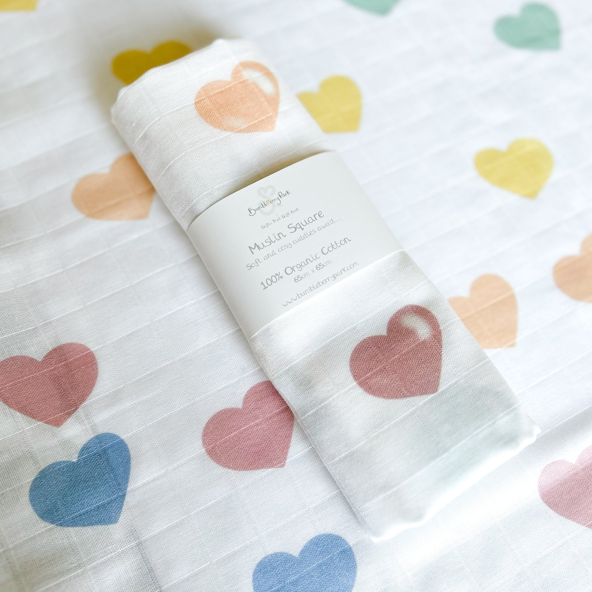 baby muslin wrap with bright rainbow coloured love hearts design