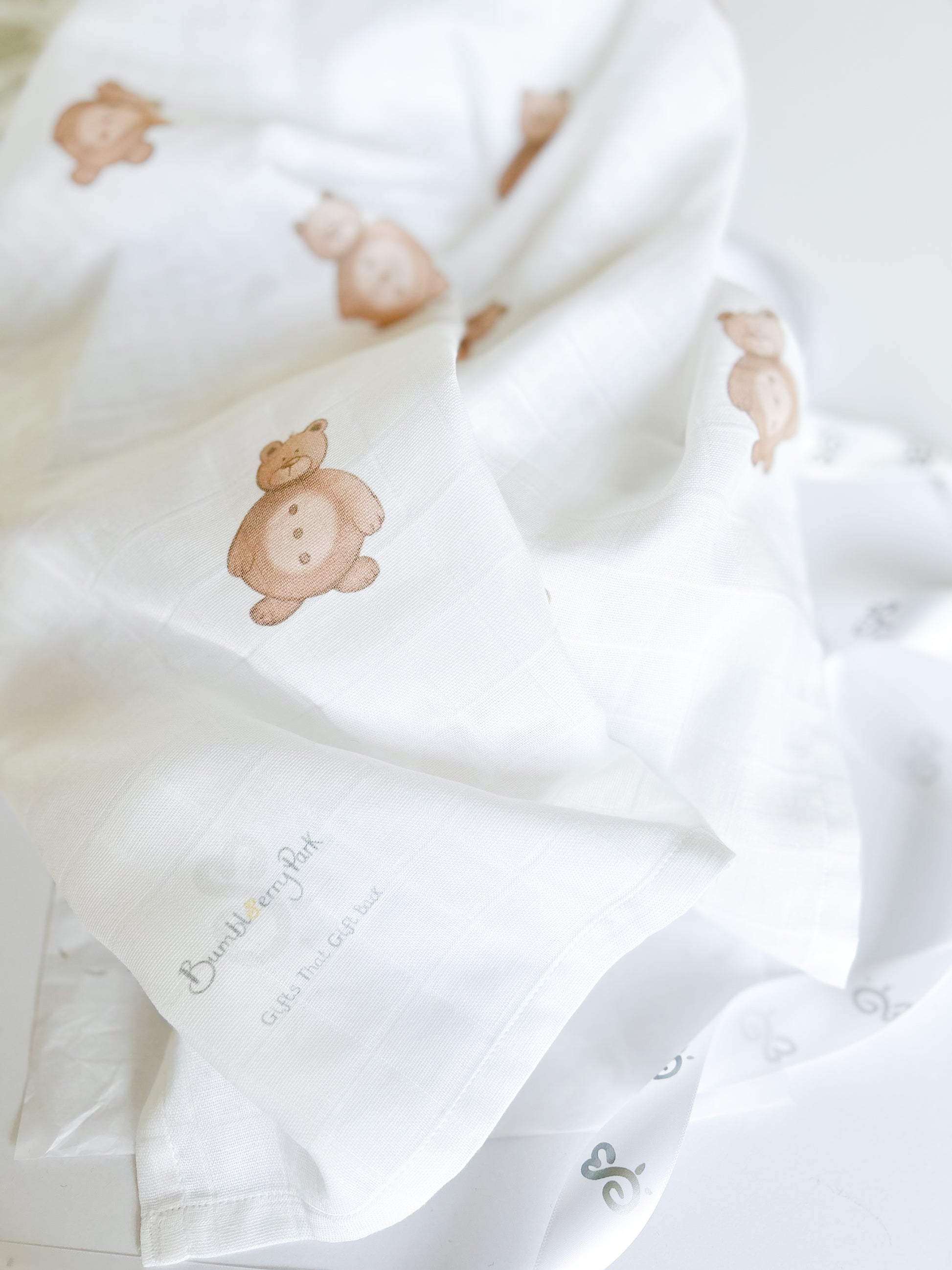 luxury white organic cotton baby muslin swaddle printed with woodland teddy bear illustrations