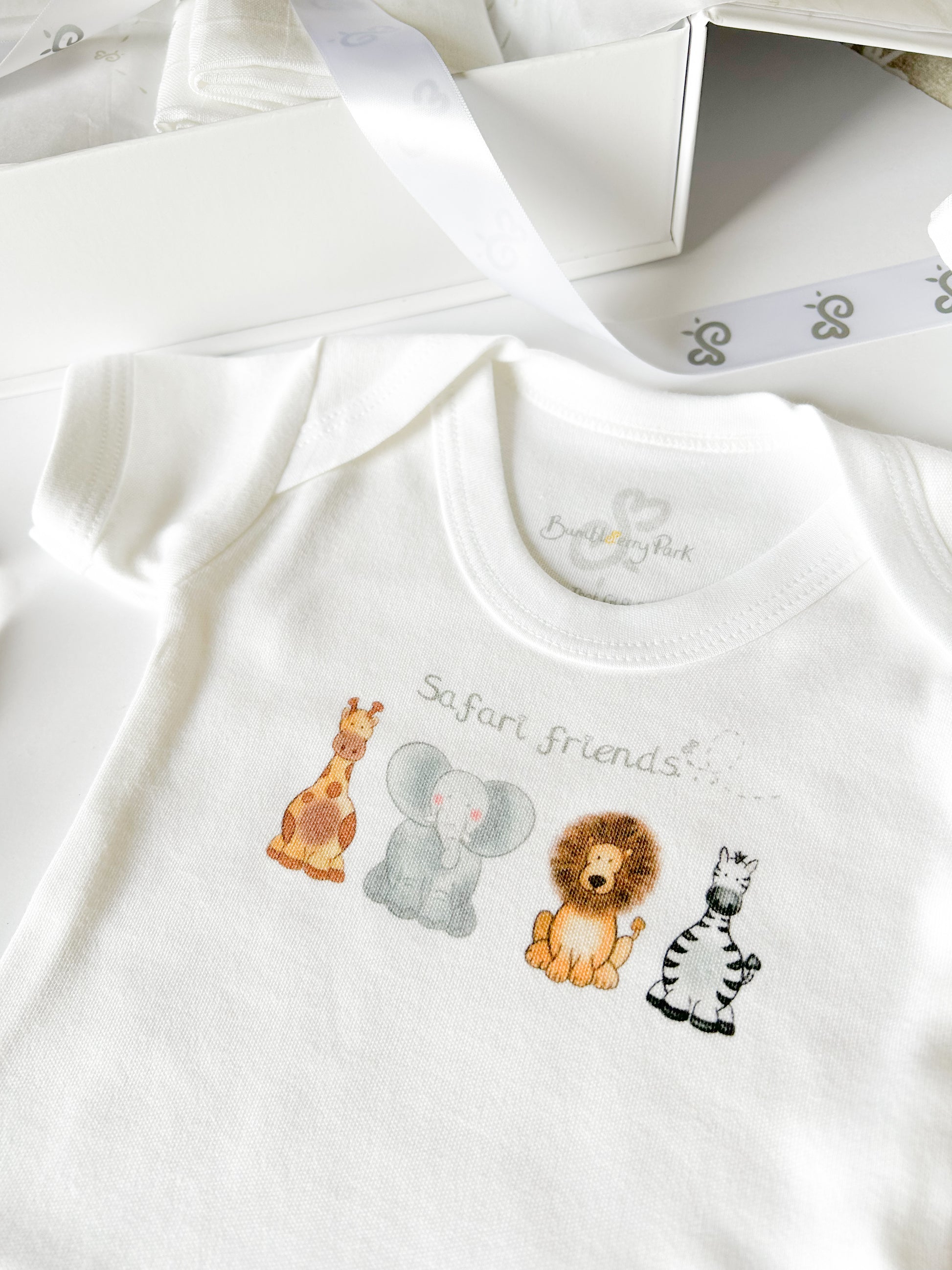 close up on a new baby bodysuit vest printed with a safari animal design