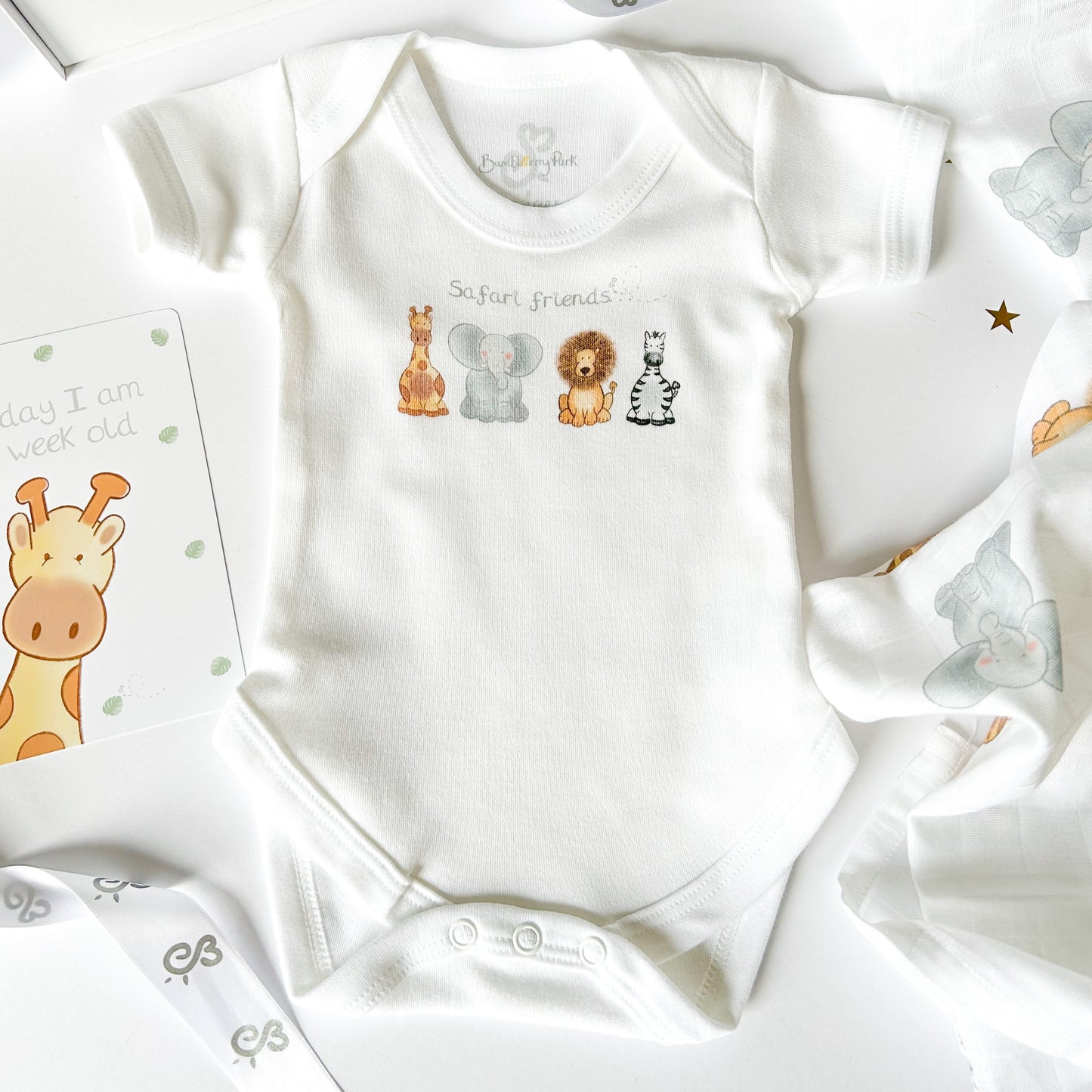 newborn baby bodysuit with a safari animal print with giraffe, lion, elephant and zebra