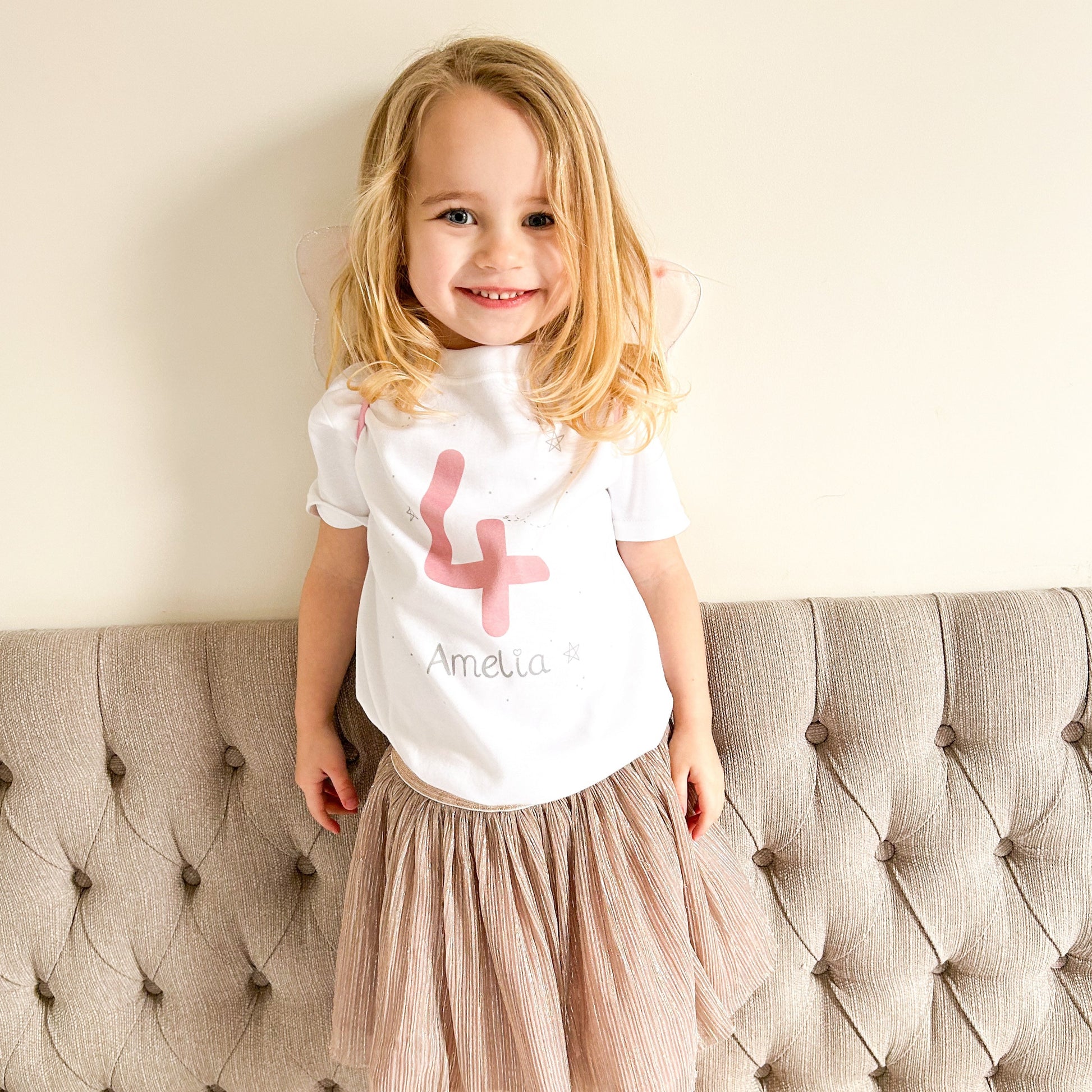 toddler girl wearing personalised birthday t-shirt pink number 4 4th birthday design and name with pink wings and a pink tutu skirt