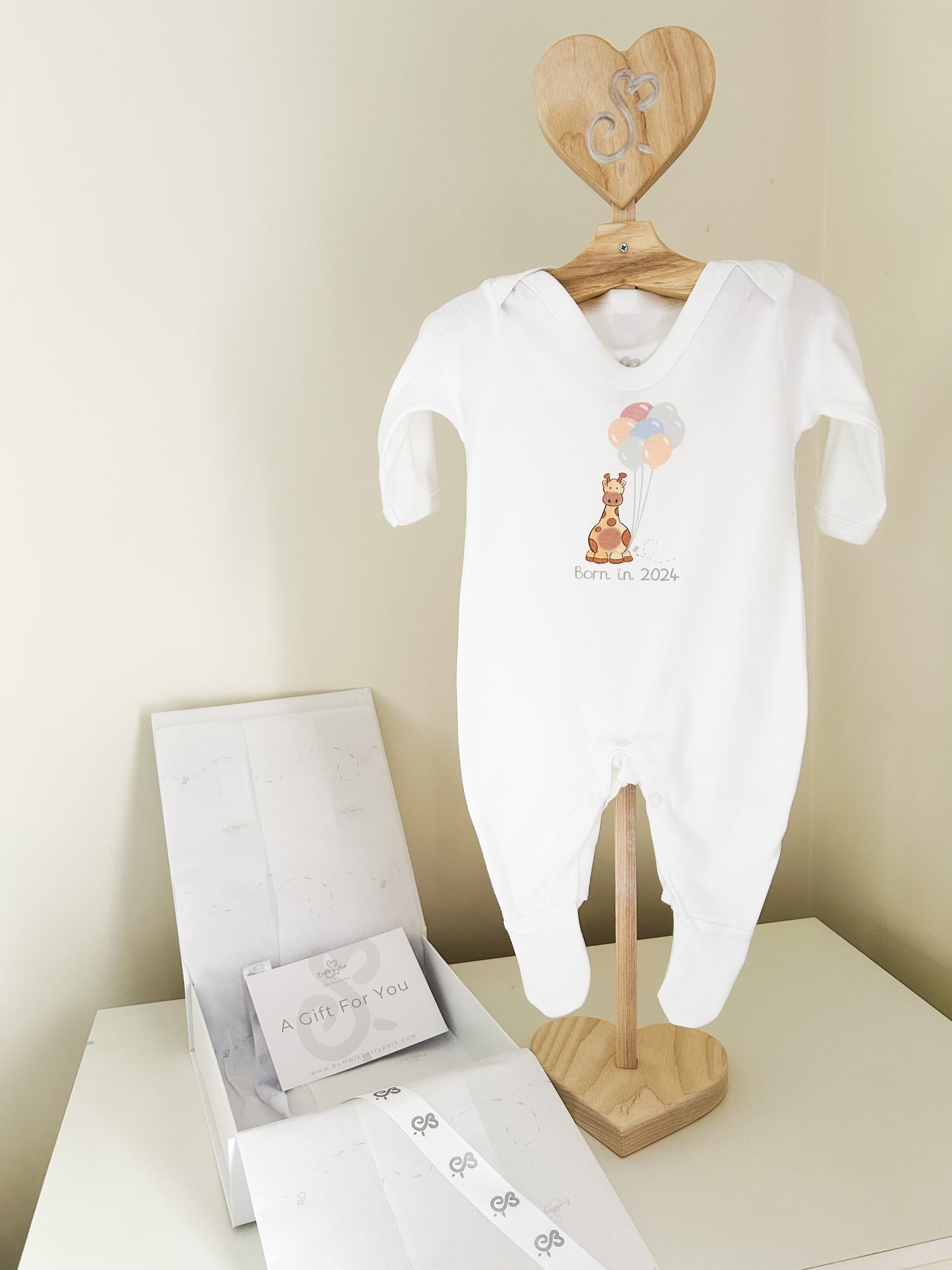 organic white baby sleepsuit babygrow printed with a safari giraffe born in 2024 design with a luxury white gift box and gift card