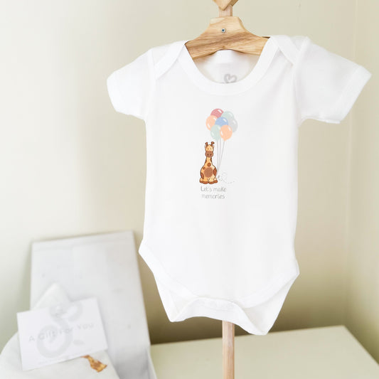 letterbox gift set for new baby including baby bodysuit vest and muslin square and nursery print with cute baby giraffe design