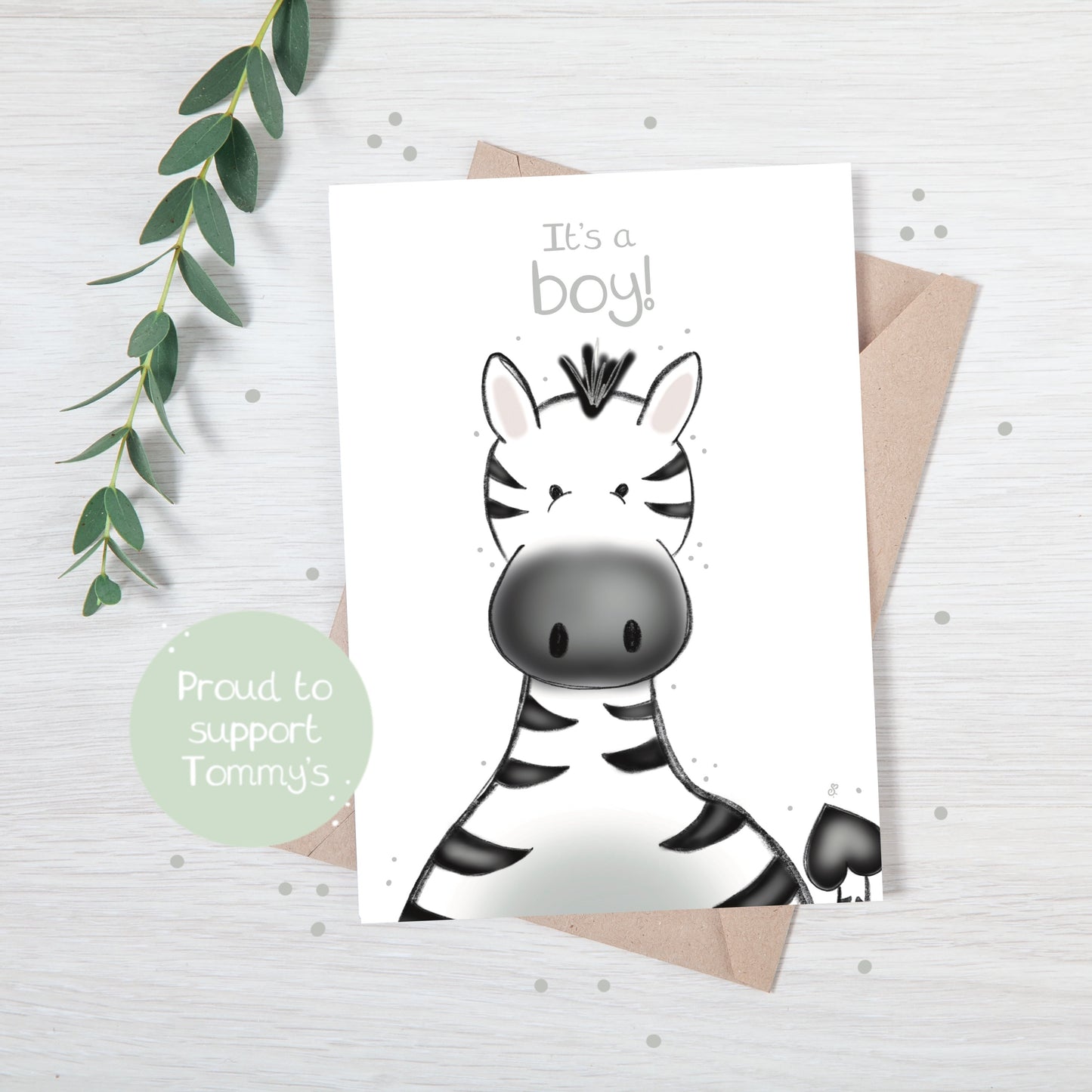 Handmade luxury new baby greetings card with a safari theme baby zebra popping up from the bottom with the title &quote "it's a boy" on a white background, with a kraft envelope